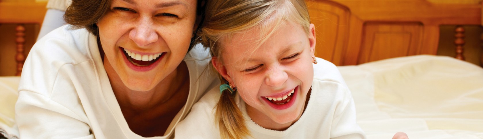 Mom and daughter reading   together a funny book