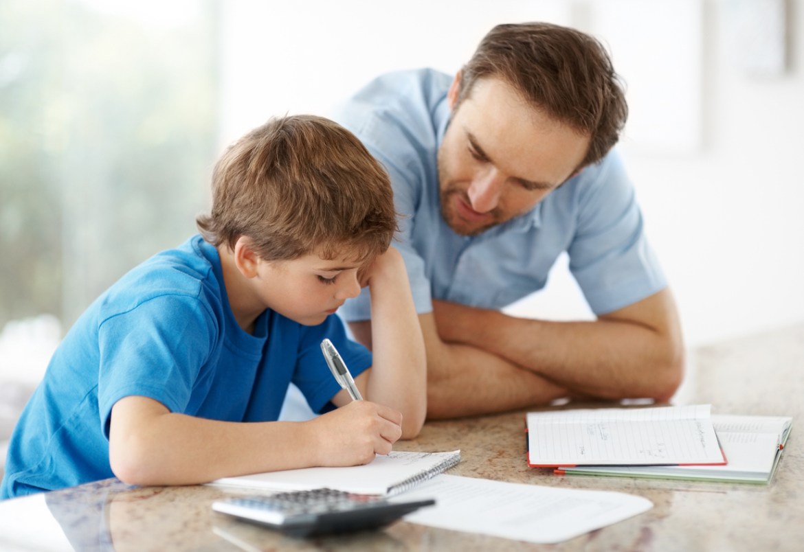 Young man assisting his little son with some home work