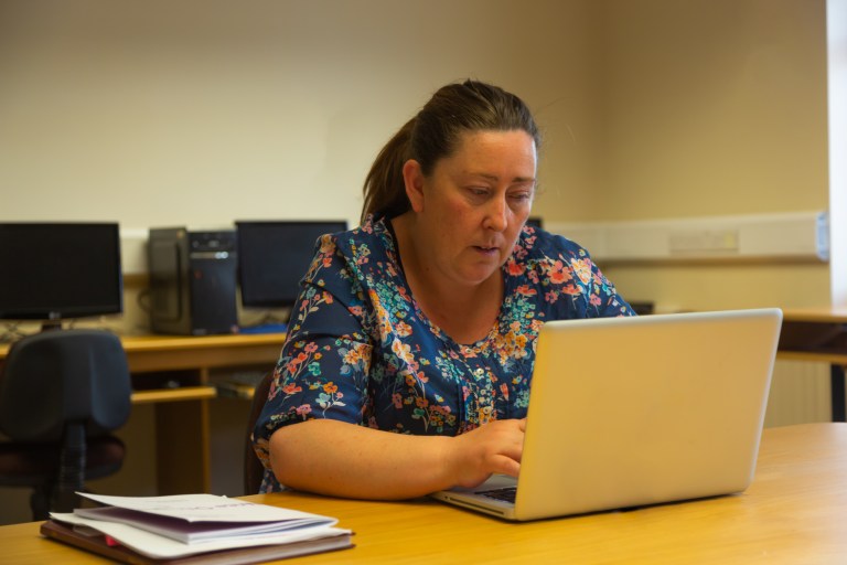 NALA Student using a laptop in a classroom