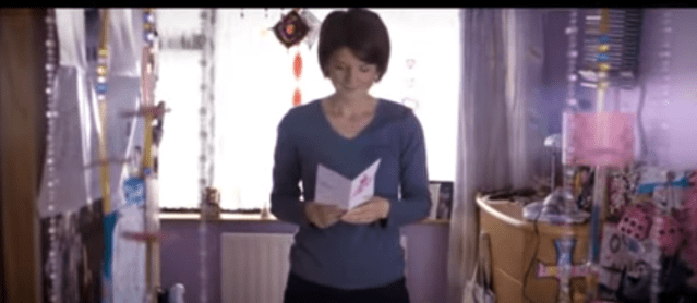 A woman in a children bedroom reading a leaflet