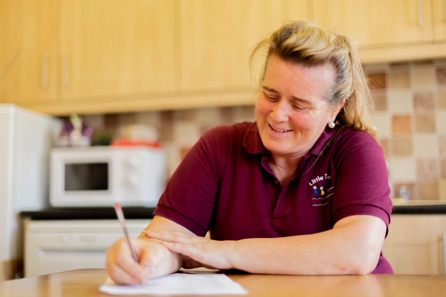 Woman in the kitchen reads a workbook