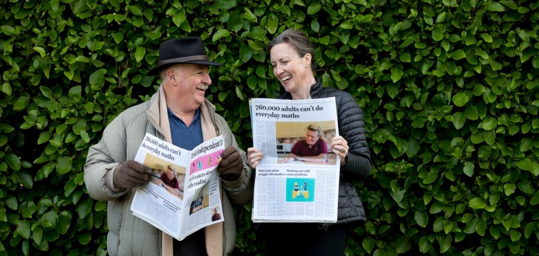 Two adults reading newspapers about adult literacy