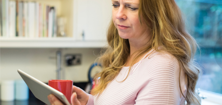 Stock image: A woman is standing up in a library while reading a book