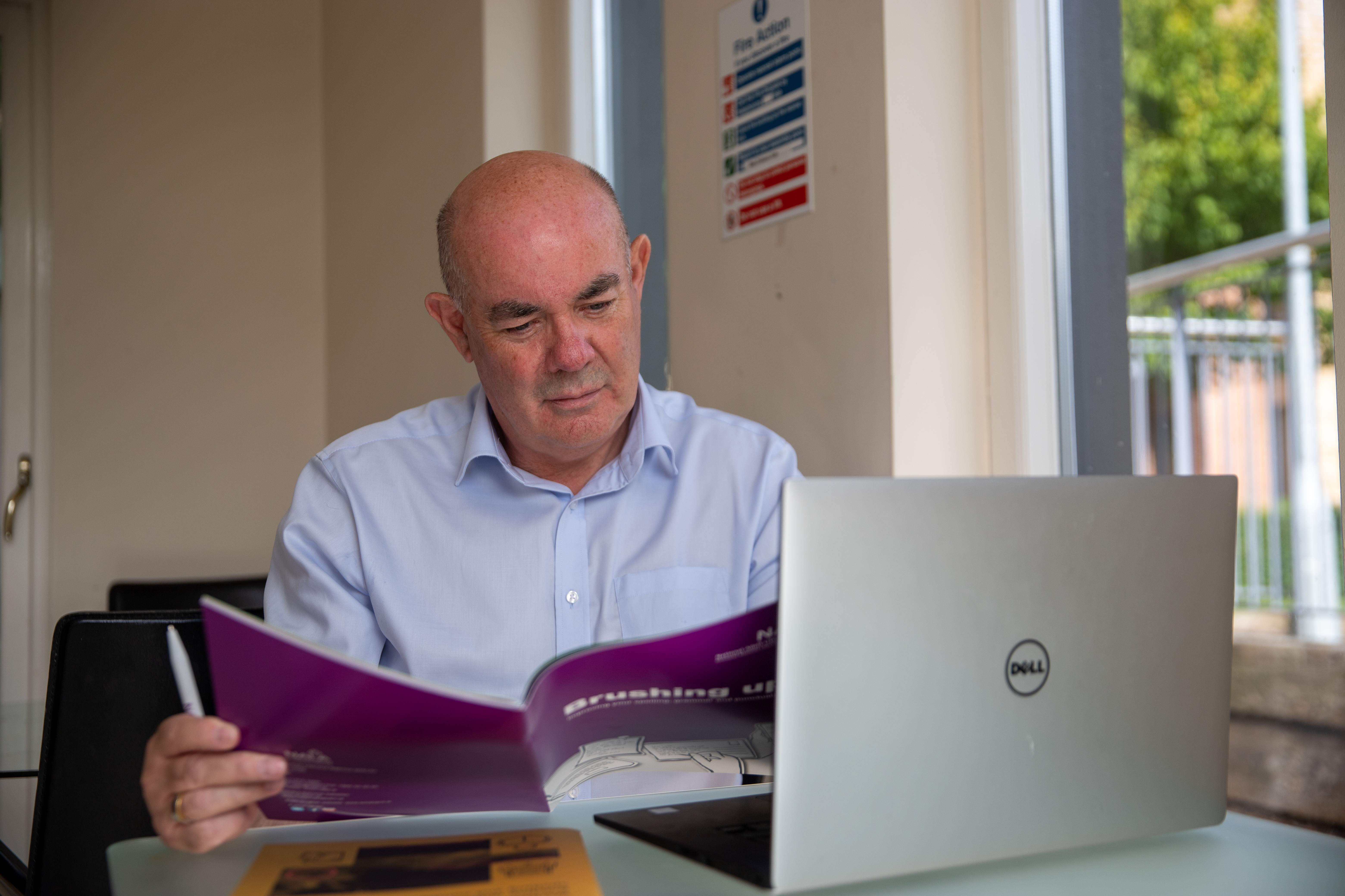 Learner using NALA workbooks at a laptop